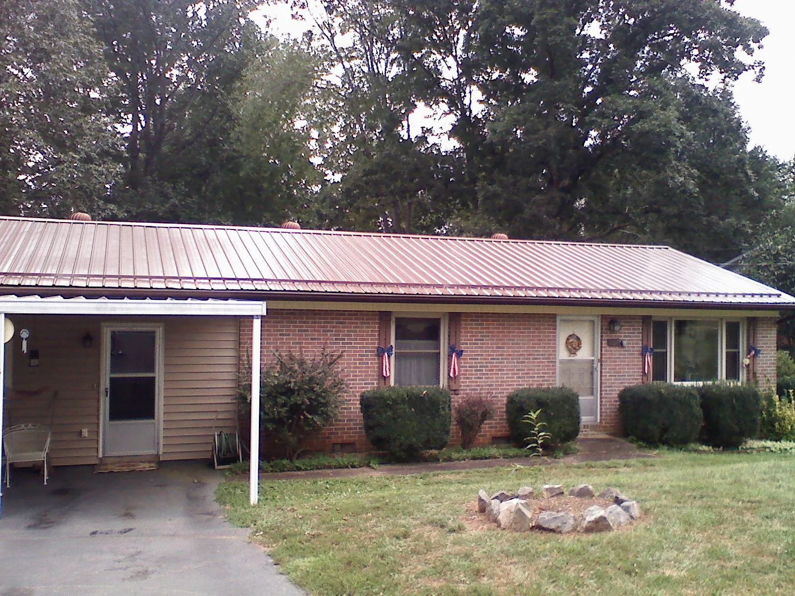 Bronze metal roof and carport on a brick ranch home — Roof Repair work by our crew in Bowen
